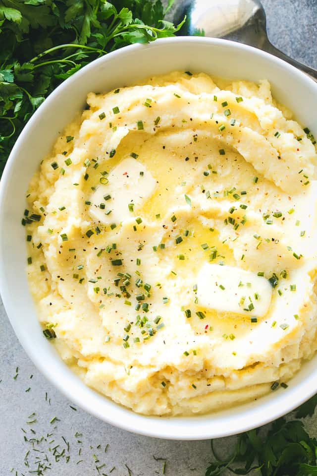 Instant Pot Mashed Cauliflower with Garlic and Chives served in a white bowl.