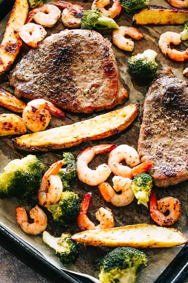 Sheet Pan Steak and Shrimp Dinner - The classic Surf and Turf dinner prepared with melt-in-your-mouth tender steak and garlicky shrimp on just one sheet pan. Broccoli and potato wedges, included!