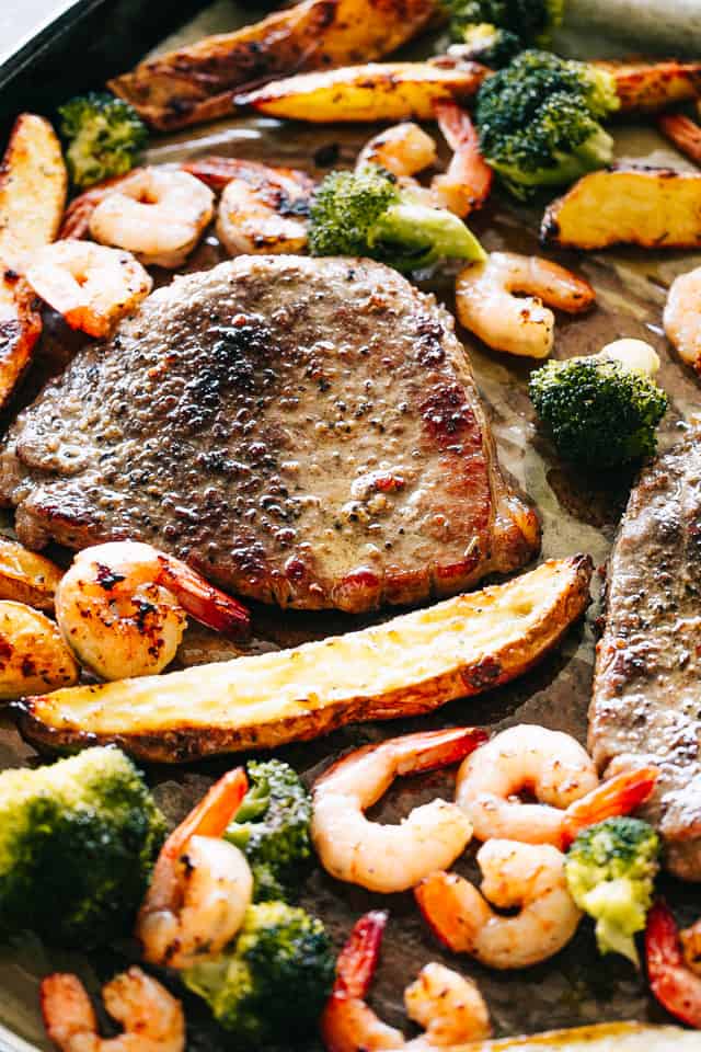 Sheet Pan Steak and Shrimp Dinner - The classic Surf and Turf dinner prepared with melt-in-your-mouth tender steak and garlicky shrimp on just one sheet pan. Broccoli and potato wedges, included!