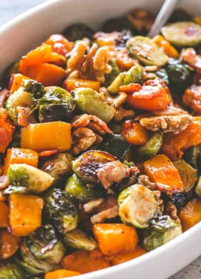 Close-up image of Maple Glazed Roasted Butternut Squash with Brussels Sprouts served in a white dish.