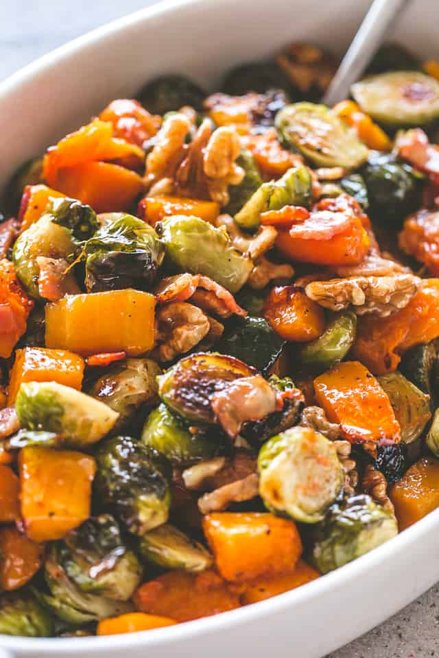 Close-up image of Maple Glazed Roasted Butternut Squash with Brussels Sprouts served in a white dish.