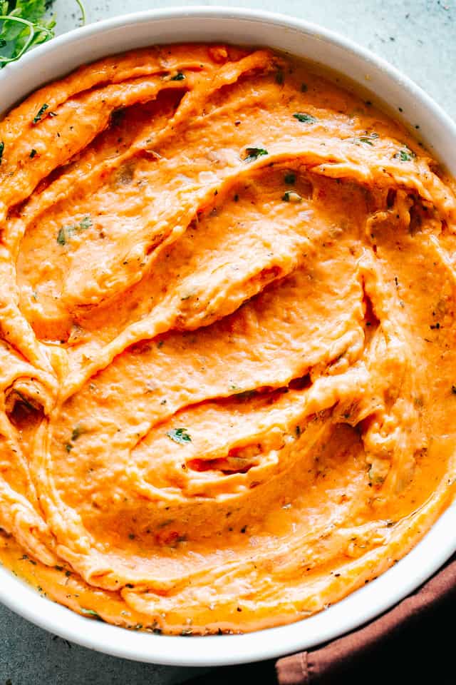 Creamy mashed sweet potatoes in a white bowl.