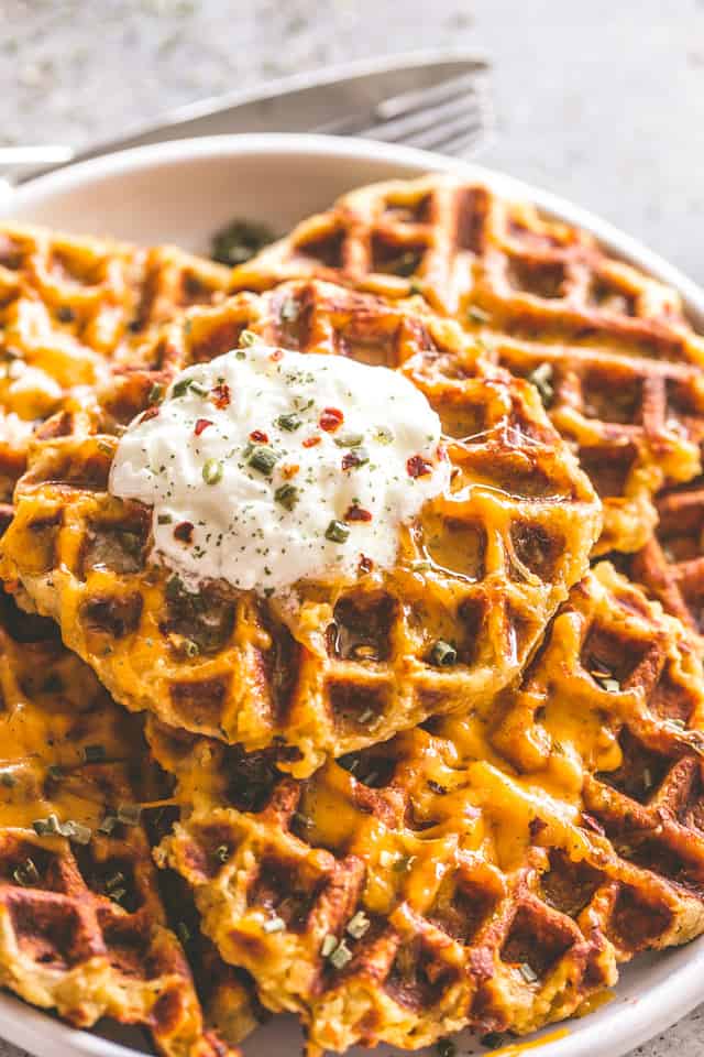 Cheesy Potato Waffles stacked on a white plate. 