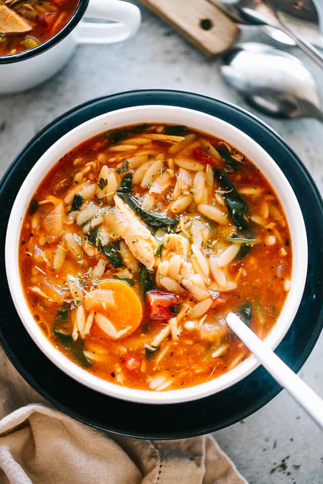 Overhead view of a bowl of leftover turkey soup with orzo and spinach.