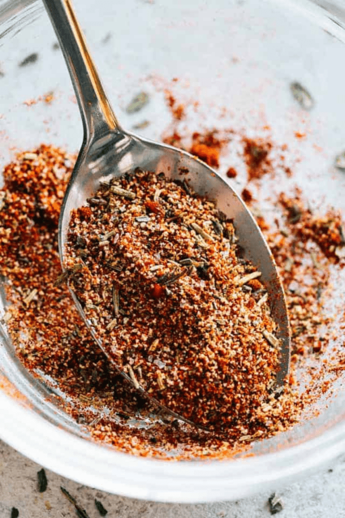 close up of a tablespoon spooning out a homemade chicken seasoning blend.