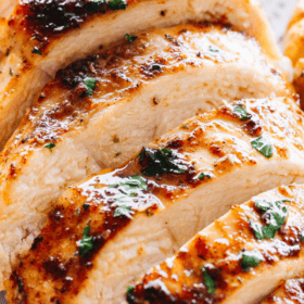 close up shot of juicy oven baked chicken breast cut into horizontal slices.