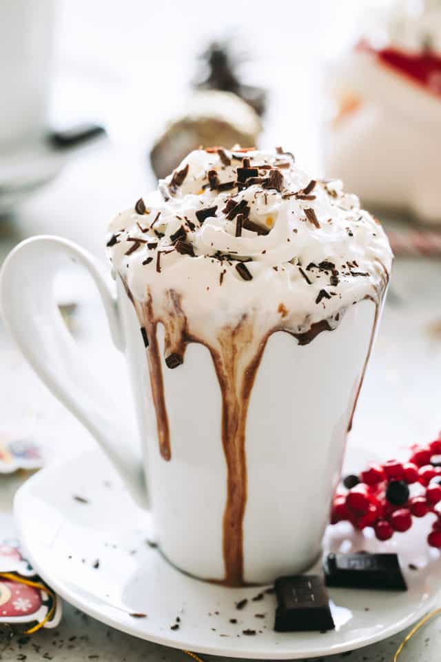 A cup of thick hot chocolate with whipped cream and chocolate shavings. 