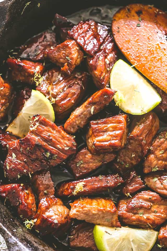 Stirring Chili Lime Steak Bites while cooking them in a cast iron skillet.