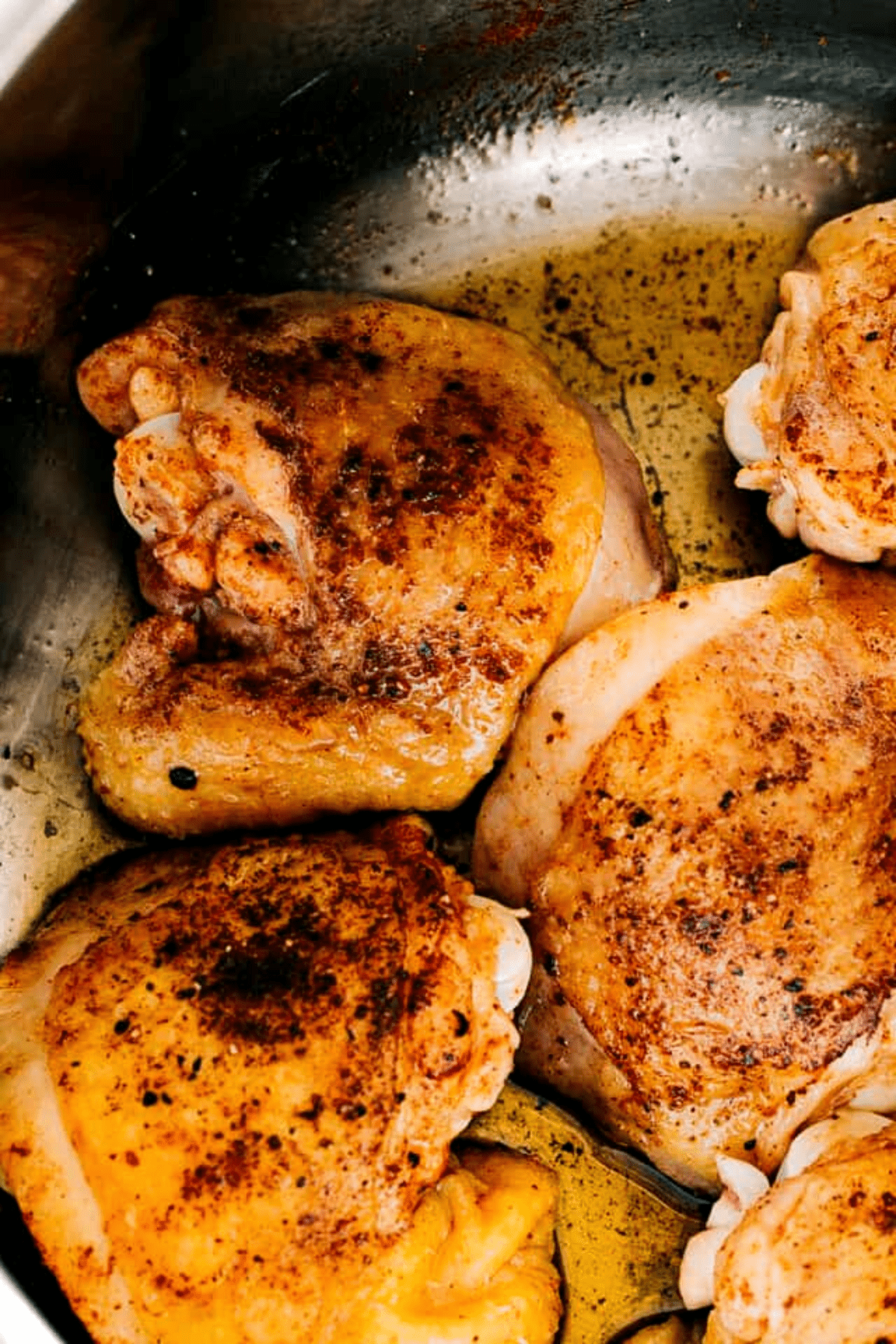 browned chicken thighs in the skillet