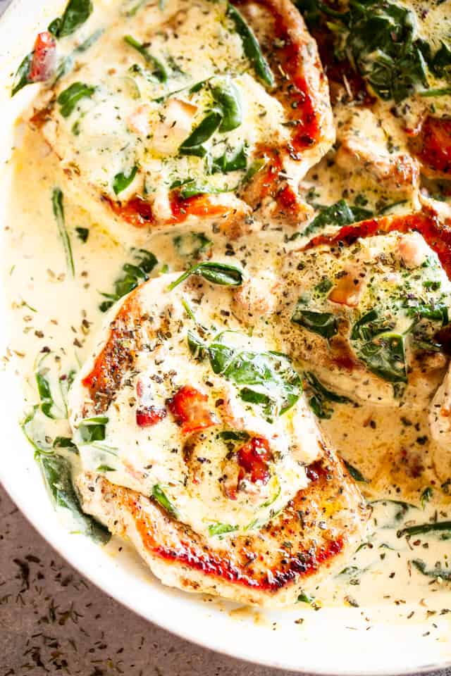 Overhead view of mustard pork chops in a skillet covered with creamy Dijon sauce.