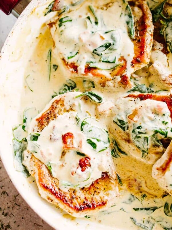 Overhead view of mustard pork chops in a skillet covered with creamy Dijon sauce.