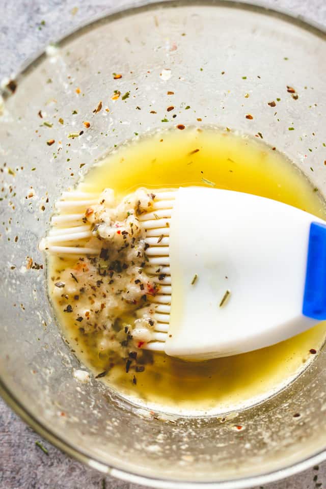 Lemon garlic butter in a glass bowl with a silicone basting brush.