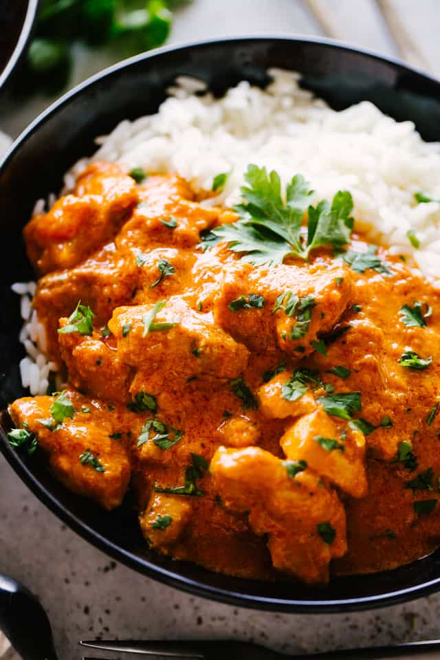 A bowl of rice with Butter Chicken on top.