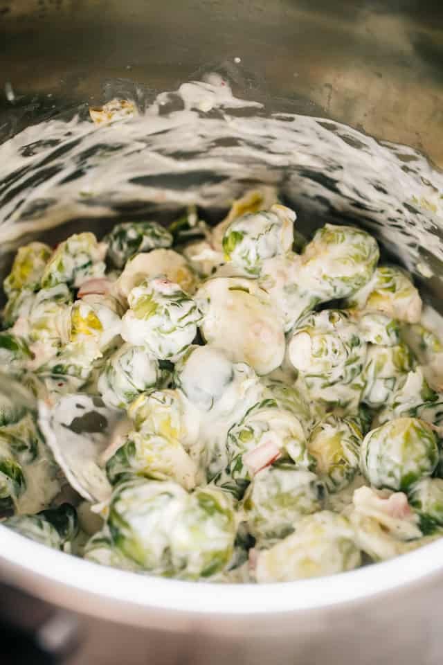 Make creamy Brussels sprouts in the Instant Pot in minutes, smothered in cheese sauce with bacon. An easy low-carb, keto-friendly side dish! Brussels sprouts and bacon smothered with cheese sauce inside the instant pot.