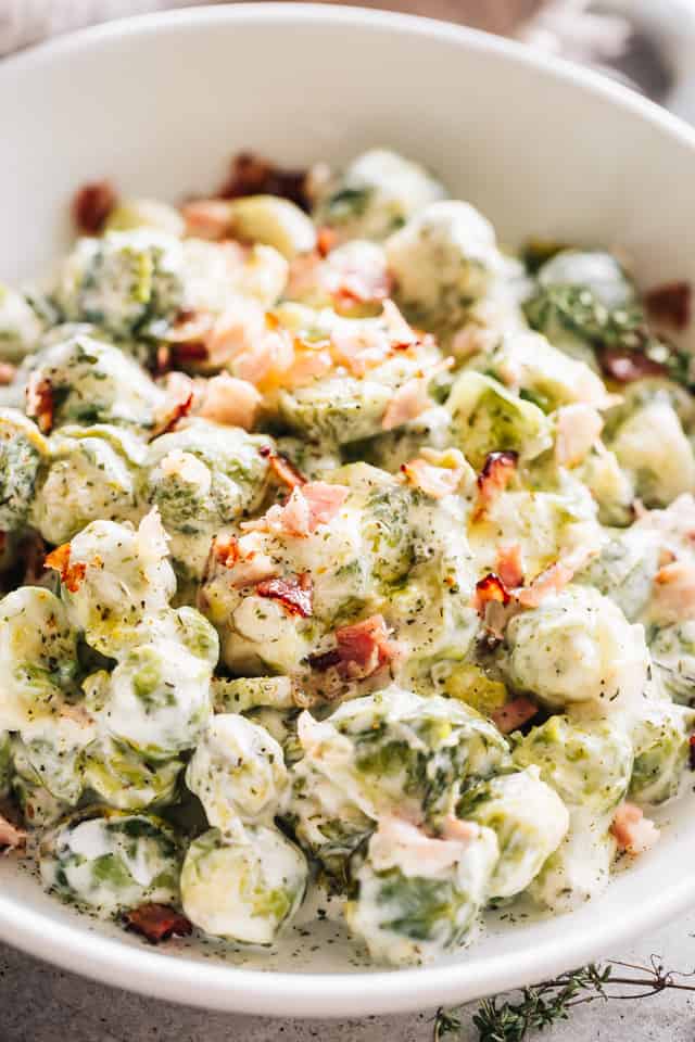 Make creamy Brussels sprouts in the Instant Pot in minutes, smothered in cheese sauce with bacon. An easy low-carb, keto-friendly side dish! Creamy instant pot Brussels sprouts with bacon in a serving bowl.