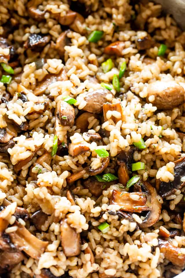 Close up overhead view of mushroom rice with green onions in it. 