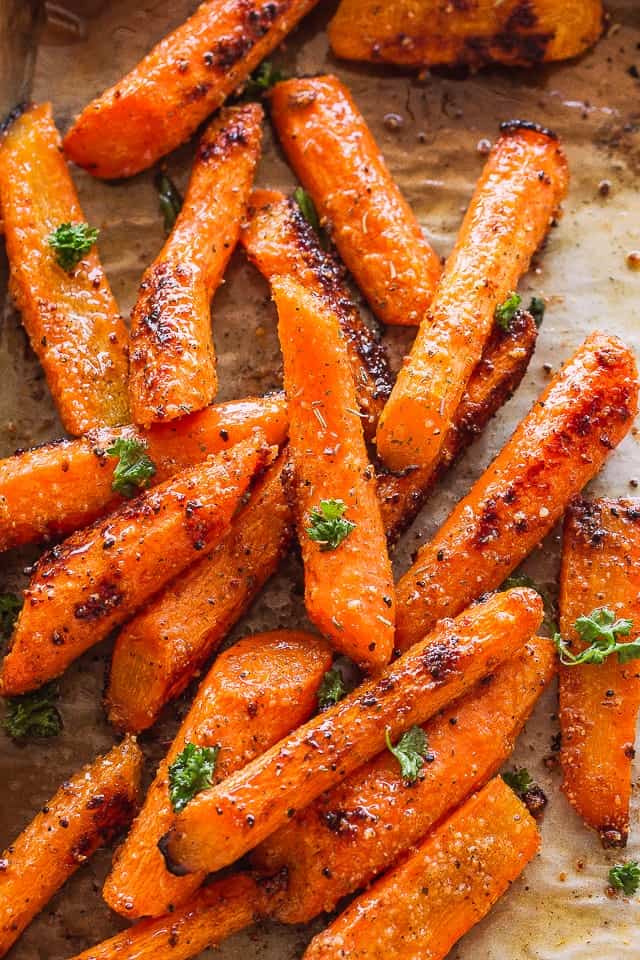 Oven Roasted Carrots spread out on a baking sheet.
