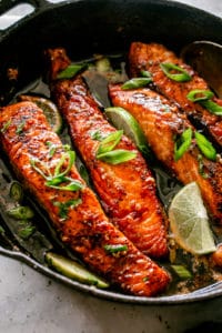 Pan seared salmon fillets in a cast iron skillet.