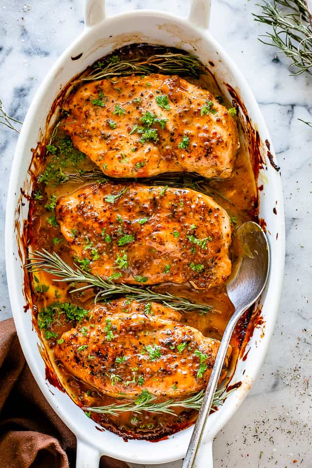 Baked Honey Mustard Chicken - The classic combination of honey and mustard smothered all over tender chicken breasts and baked to a succulent perfection. Honey Mustard Chicken in a baking dish.