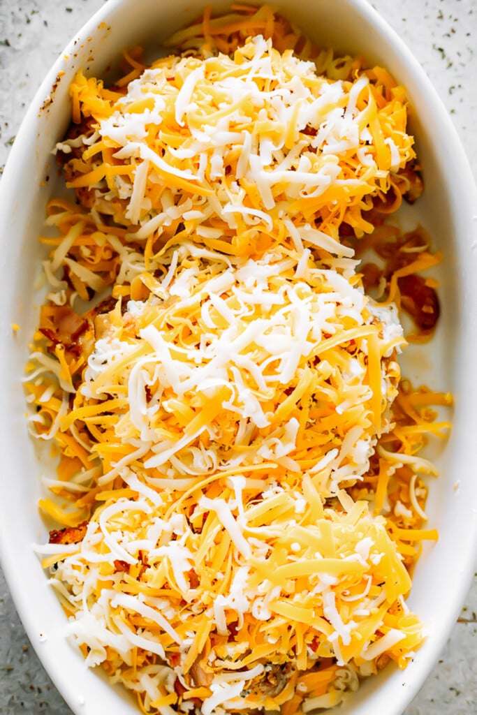 three chicken breasts topped with shredded cheese.