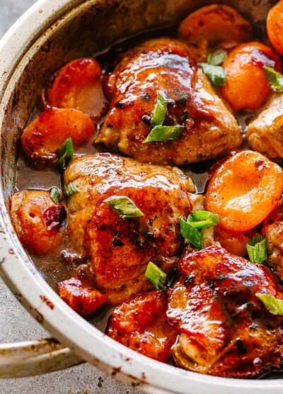 Barbecue Apricot chicken thighs in a skillet.