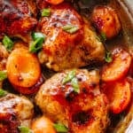 chicken thighs in a skillet with apricots.