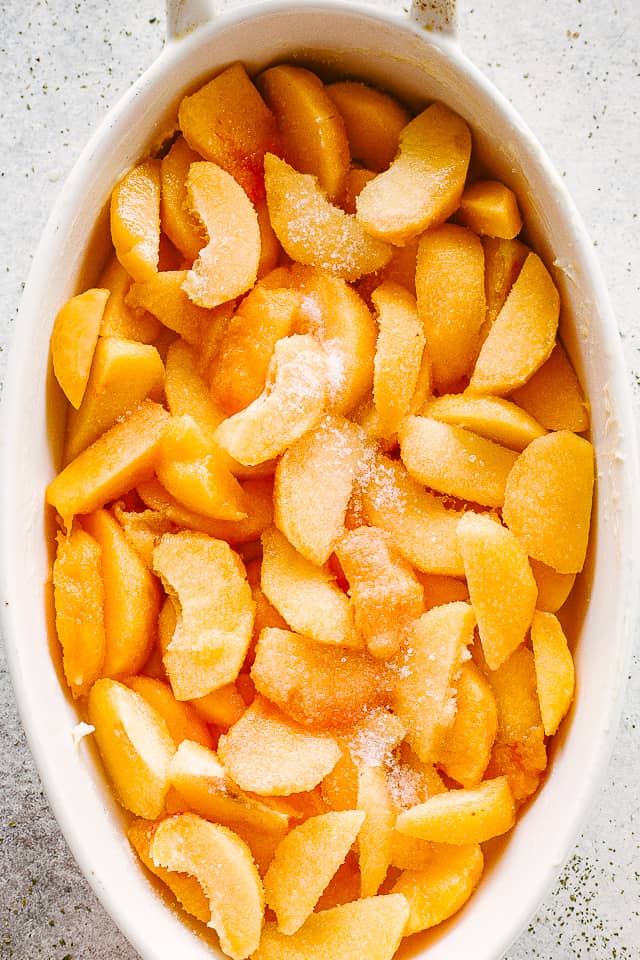 Fresh peaches sliced and arranged in a baking dish.