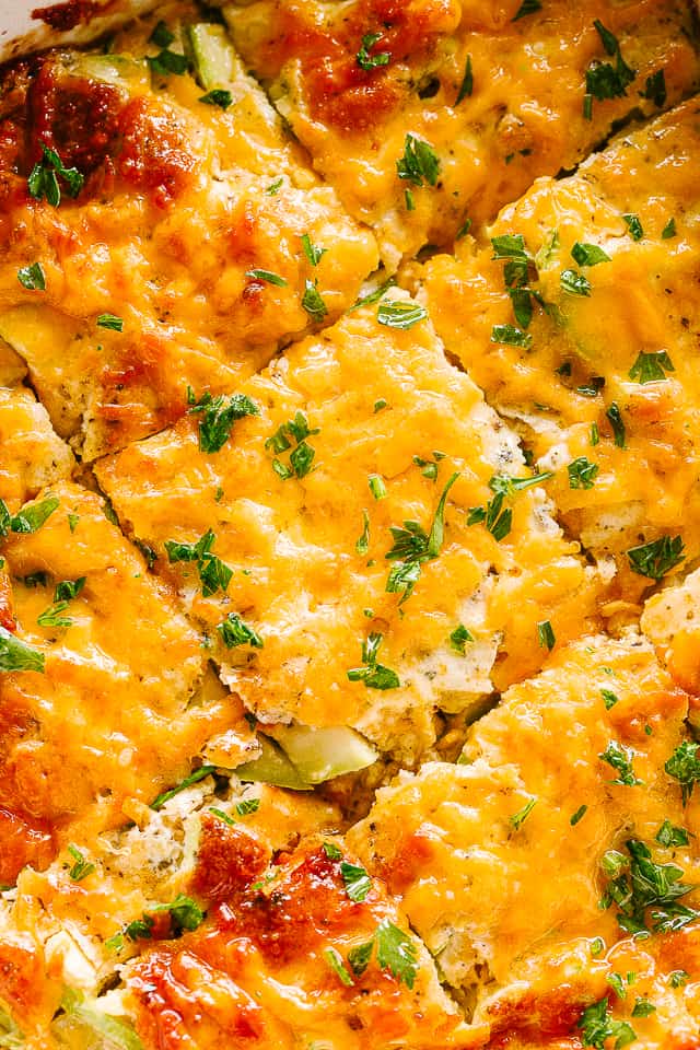 Baked cheesy zucchini casserole cut in squares.