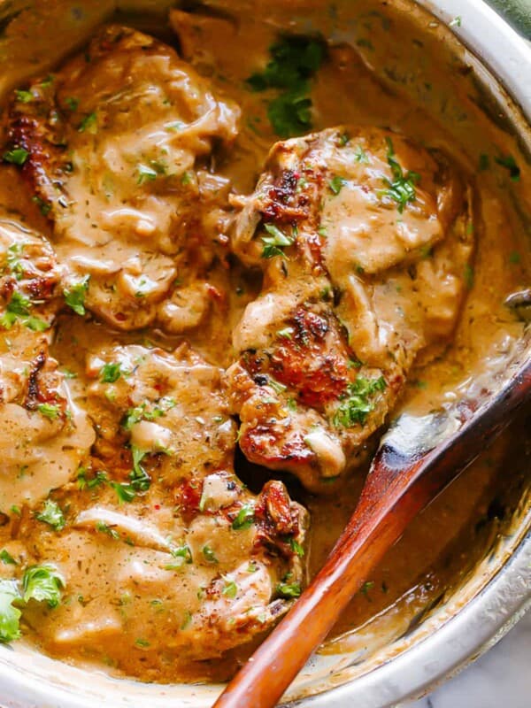 Overhead shot of smothered pork chops with onion gravy in a skillet.