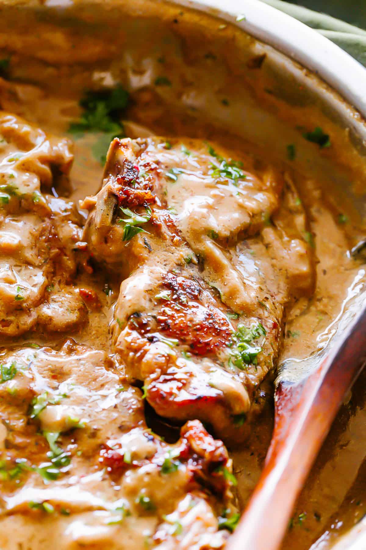 Close-up view of pan-seared pork chops with onion gravy in a skillet