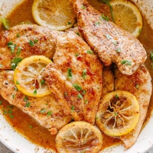 Lemon pepper chicken breasts in a skillet.