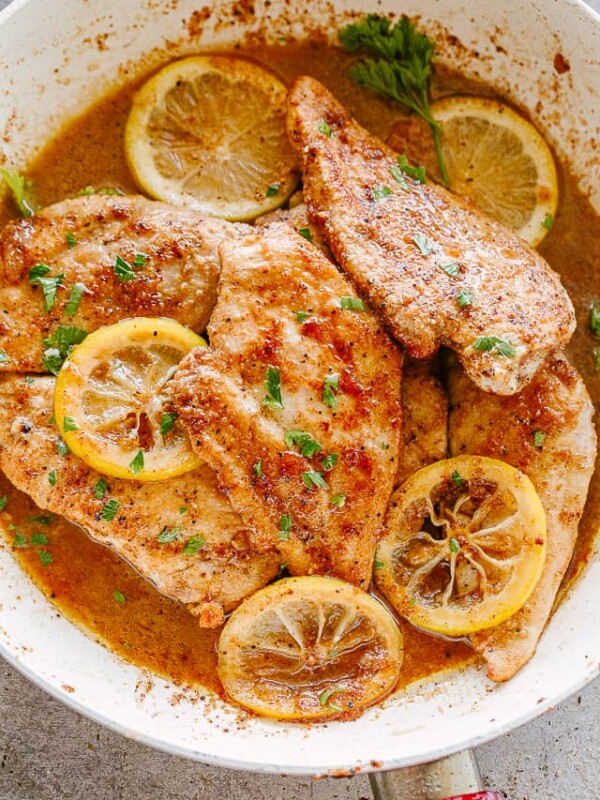 Lemon pepper chicken breasts in a skillet.