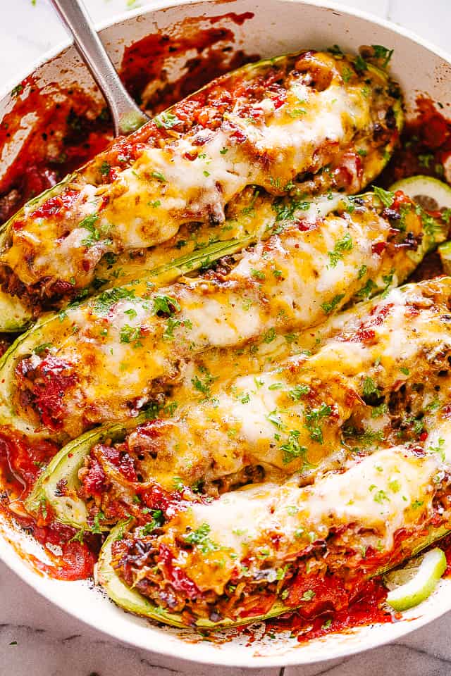 Taco meat stuffed zucchini in a baking dish.