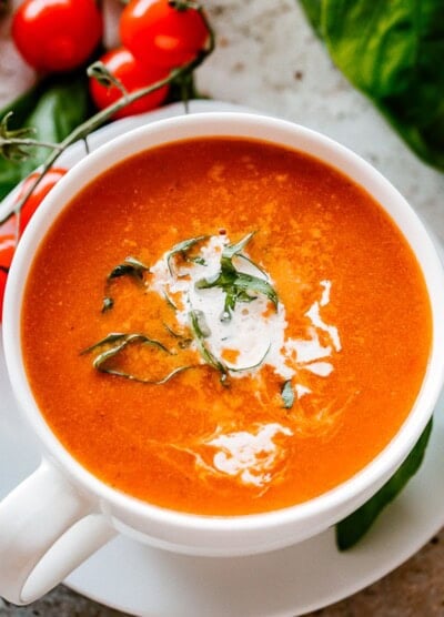Bowl of Roasted Tomato Soup garnished with basil and parmesan cheese.