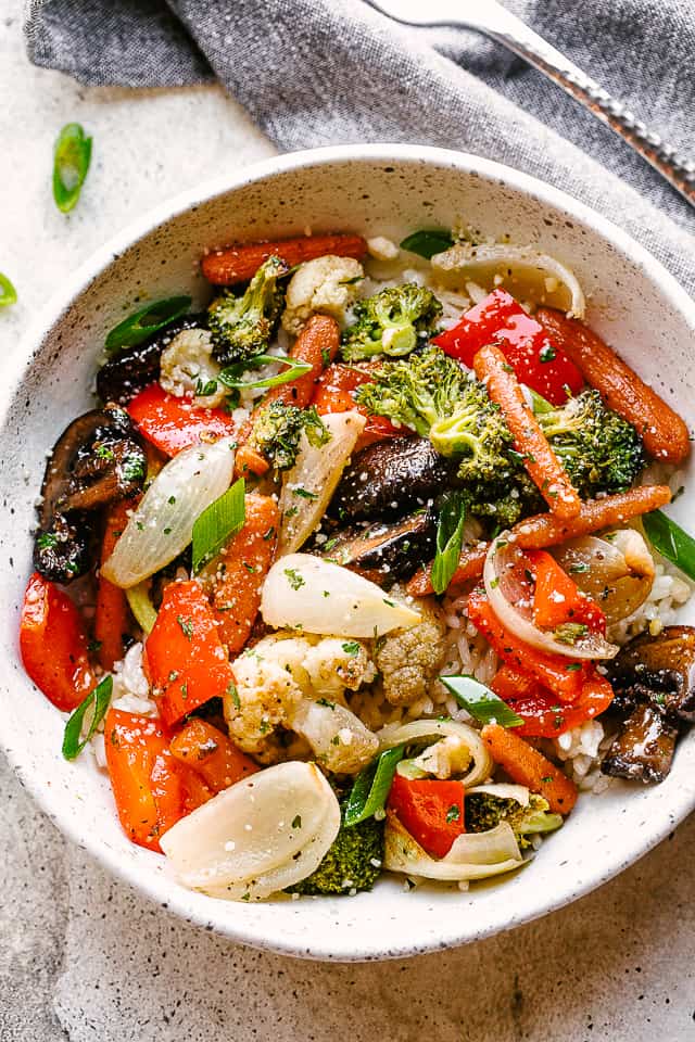 Roasted vegetables served over a bowl of rice.