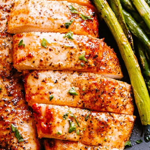 Air Fryer prepared chicken breasts served with asparagus.