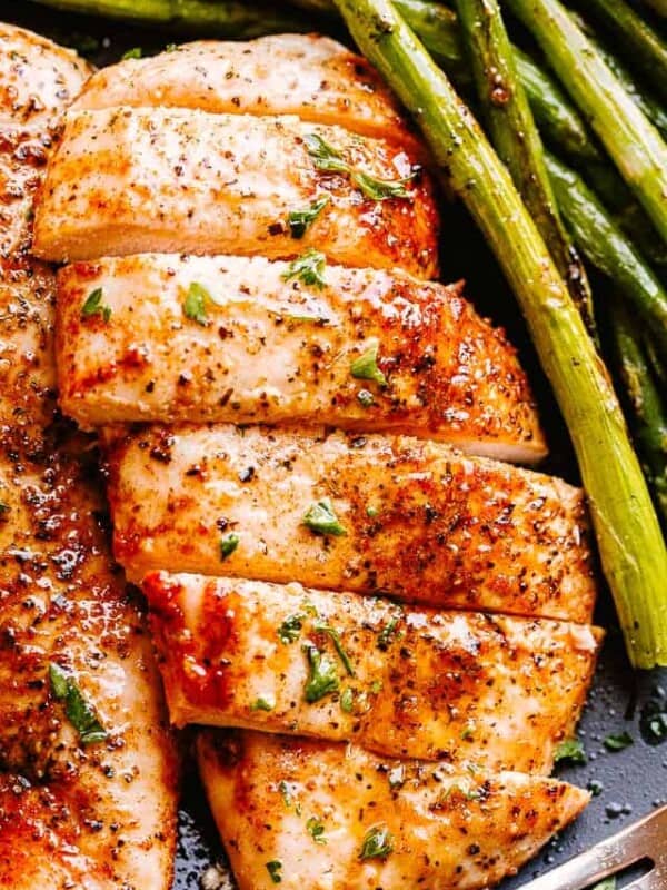 Air Fryer prepared chicken breasts served with asparagus.
