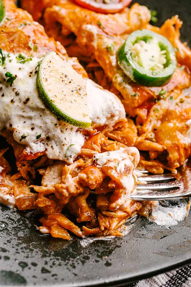 Cutting into an enchilada with fork.