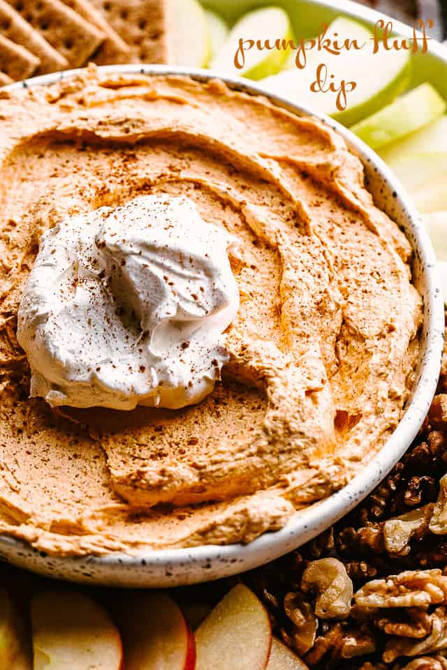 Pumpkin Fluff Dip served in a bowl with a dollop of whipped topping.