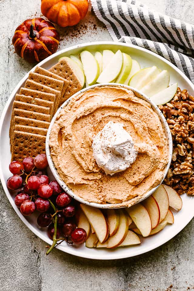 Pumpkin Fluff Dip served with apples, grapes, nuts, and cookies.