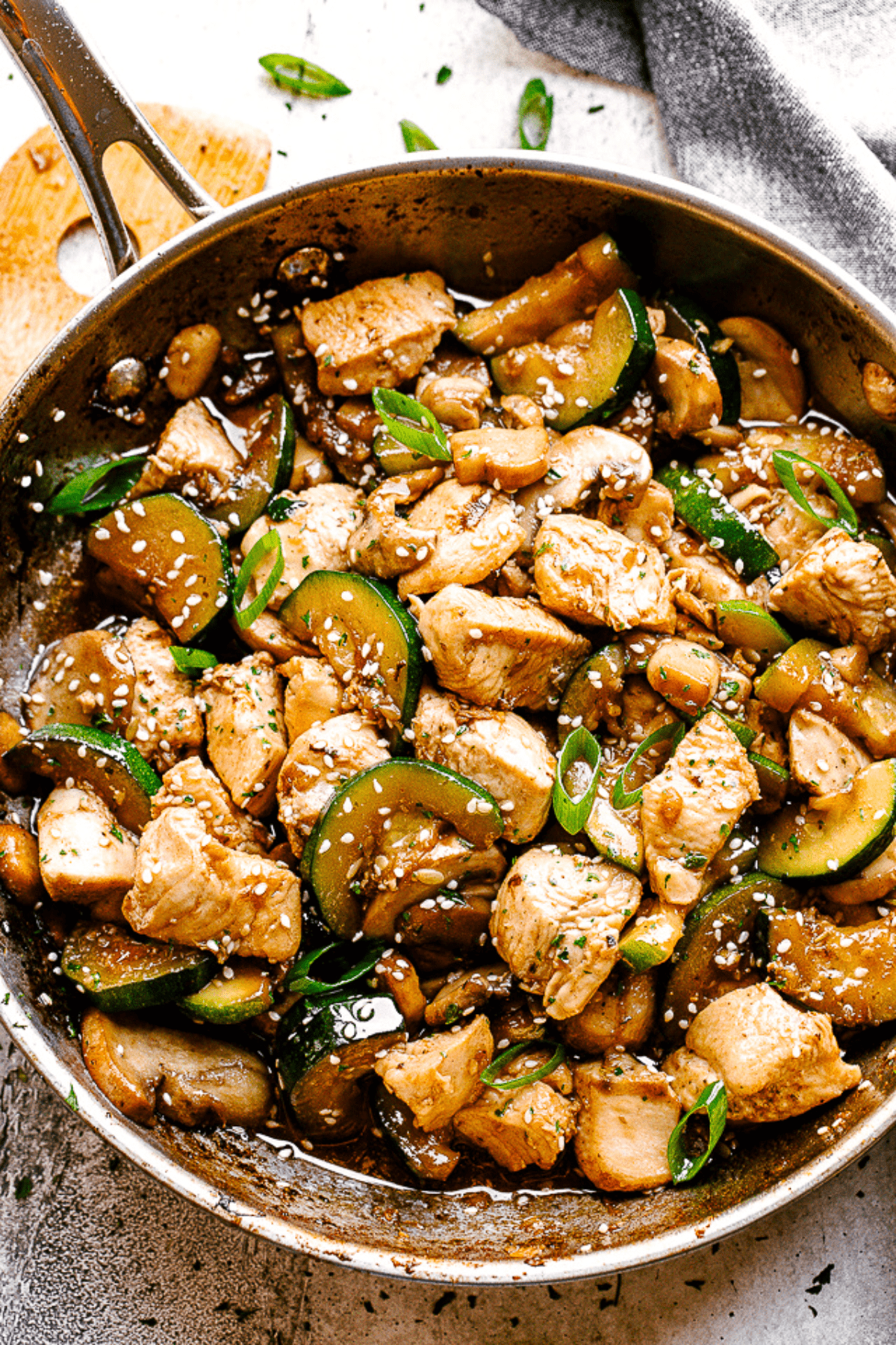 Photo of a skillet with stir fry chicken, mushrooms, and zucchini.