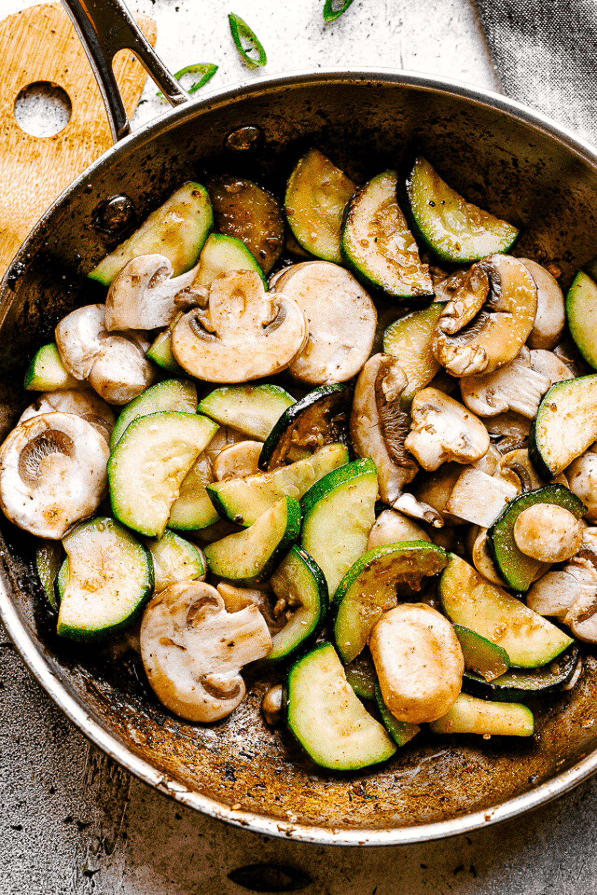 Stir frying sliced zucchini and mushrooms in a skillet.