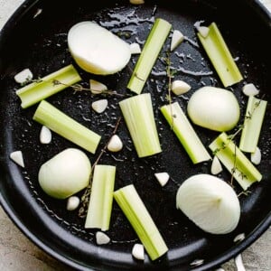 onion wedges, garlic, and celery in a roasting pan.