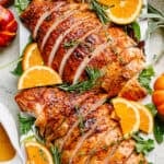 Close up of sliced turkey breast garnished with orange slices.
