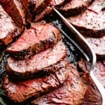 Sliced beef tenderloin with serving fork.