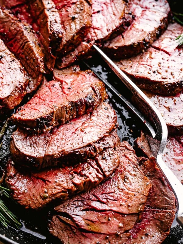 Sliced beef tenderloin with serving fork.