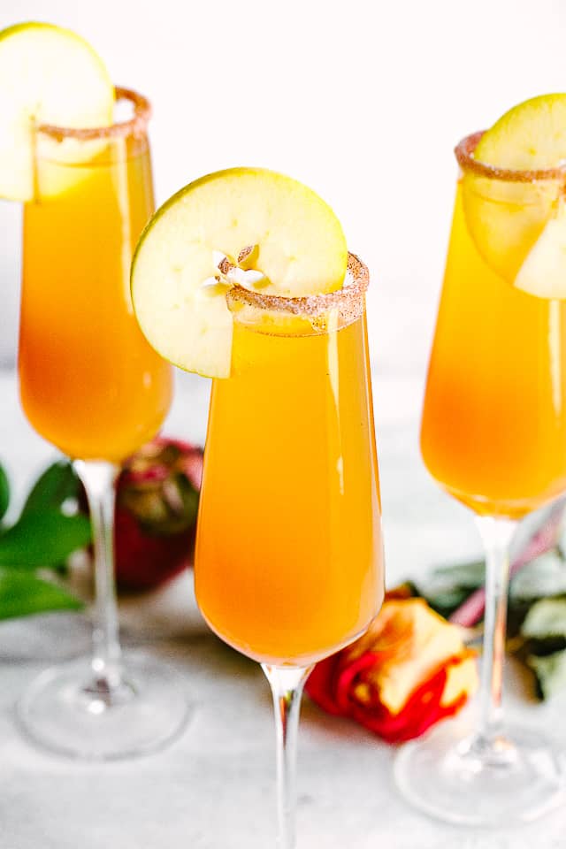 apple cider mimosas in glasses with cinnamon sugar. 