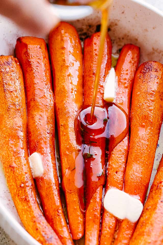 pouring maple syrup over carrots.