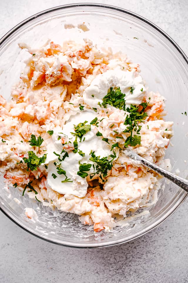 Cream cheese and shrimp mixed in a glass bowl