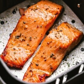 Cooked salmon fillets in an air fryer basket